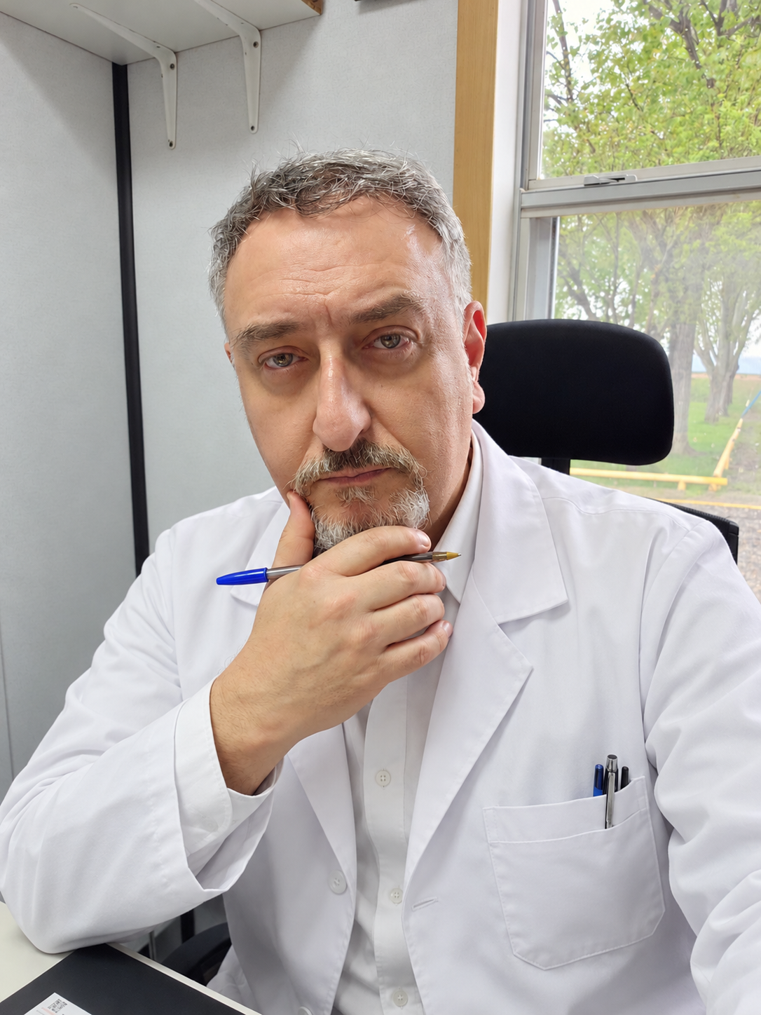Dr. Miguel Alejandro Brahím con guardapolvo blanco en su consultorio